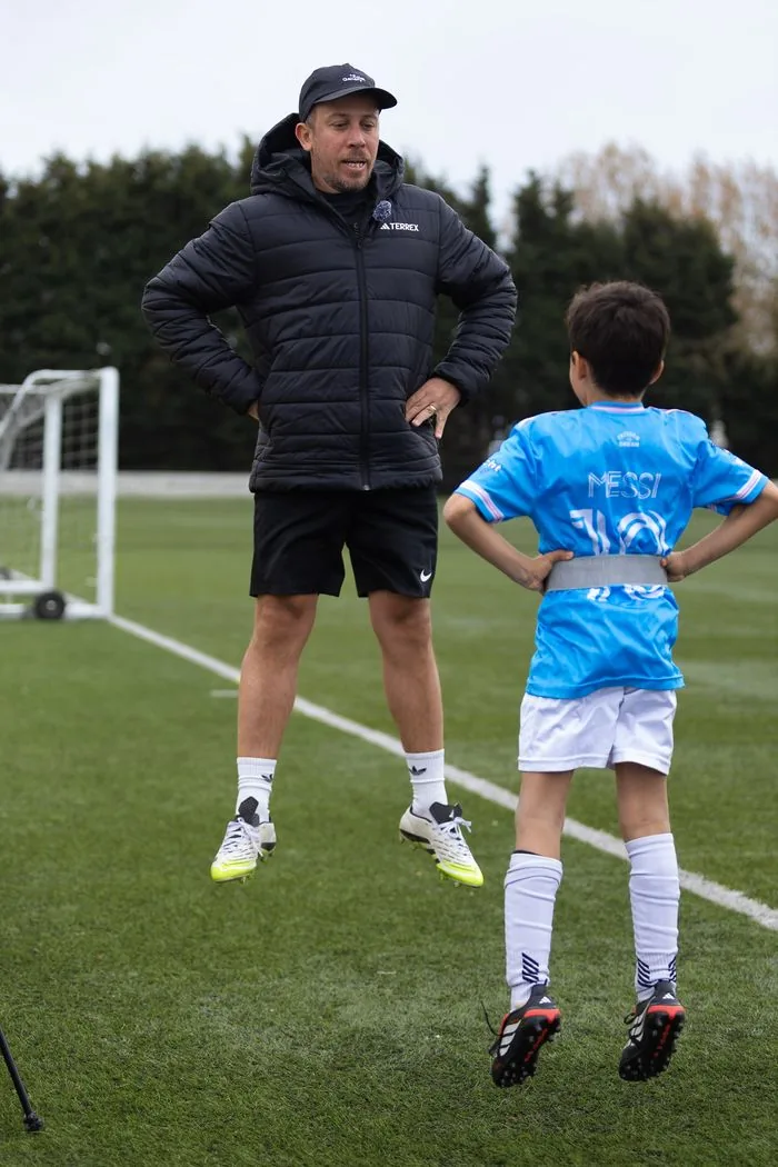 EPP coach demonstrating jump technique alongside young athlete
