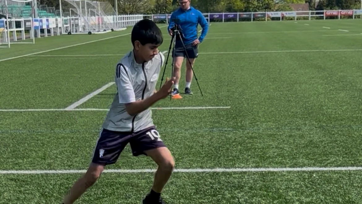 EPP coach Cameron O'Neill operating Photon Sports timing equipment during a football agility test with a young athlete