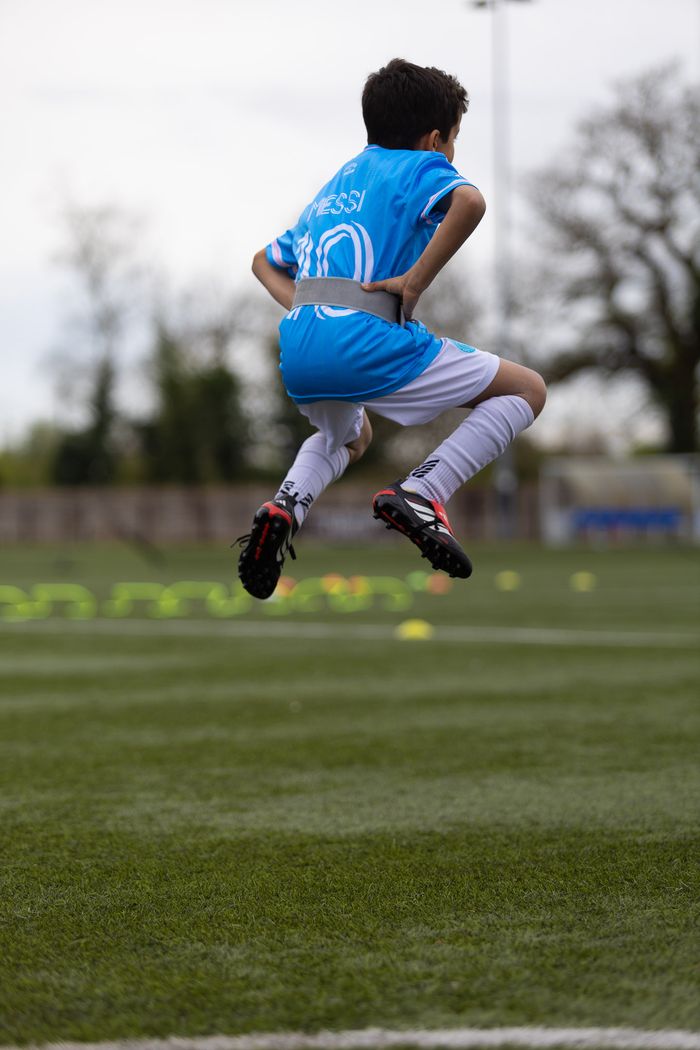 U8 youth athlete performing plyometric jump test at EPP speed and agility class Birmingham — clean technique with Photon Sports sensor